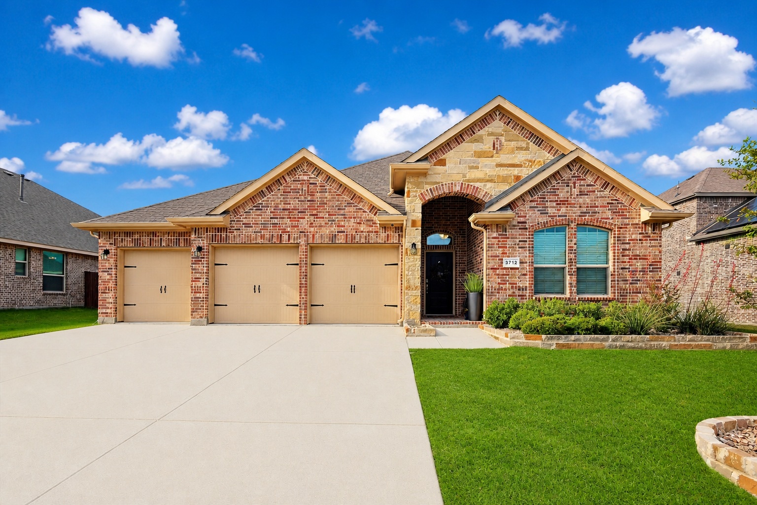 3712 Rolling Meadows Drive exterior view showing brick facade with 3-car garage
